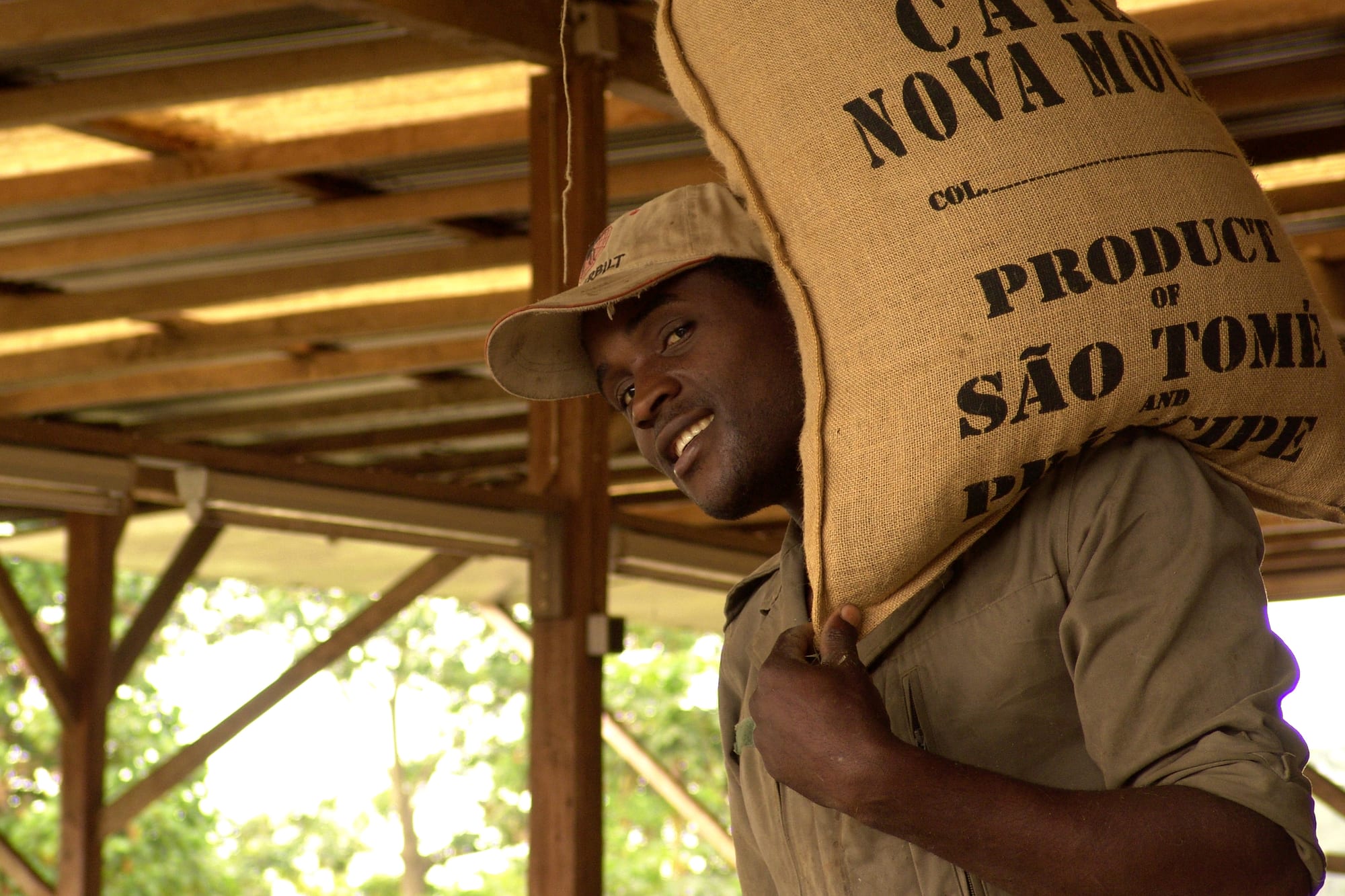 Un uomo trasporta sulla spalla un sacco di cacao a Sao Tomè e Principe